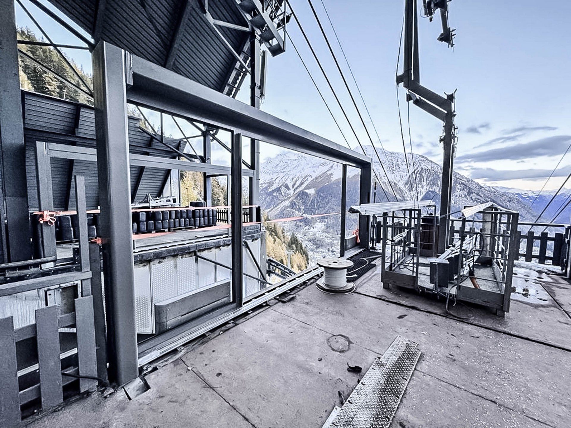 [Translate to French-French:] Bergstation mit Bahnsteigbereich und Blick auf die Berge dahinter.