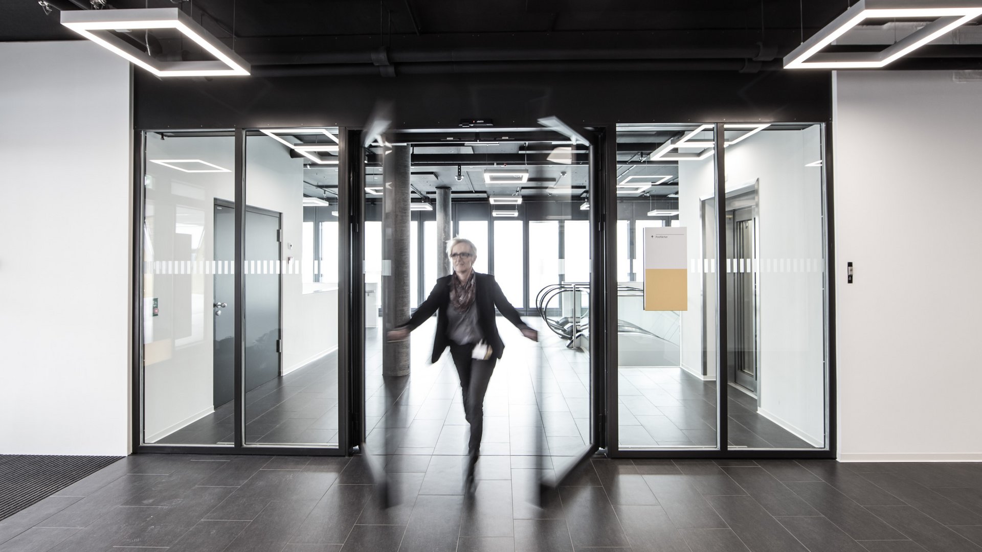 Fluchtweg Schiebetür mit einer flüchtenden Person im Postparc in Bern